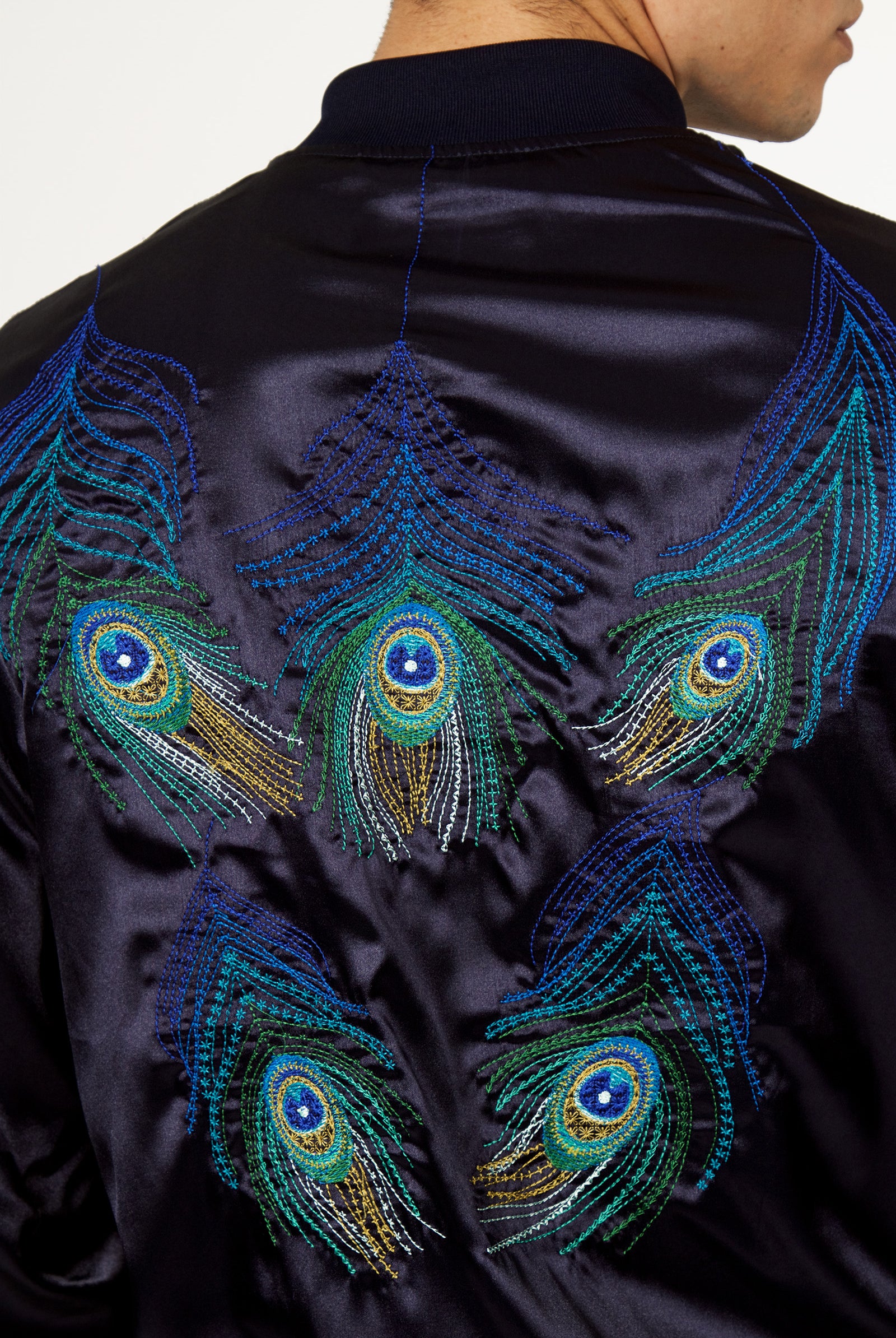 Mannequin homme de dos blouson satin marine avec broderies raffinées plumes de paon