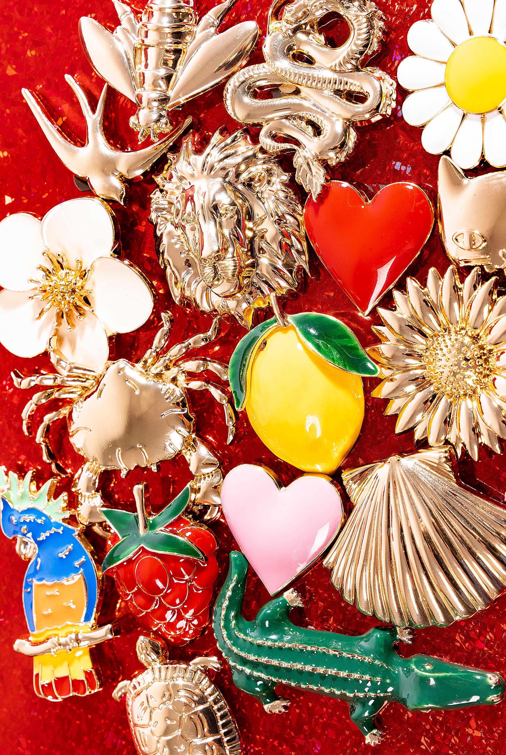 Bijoux clap paris disposés sur fond rouge idées cadeaux broches à clipper misericordia