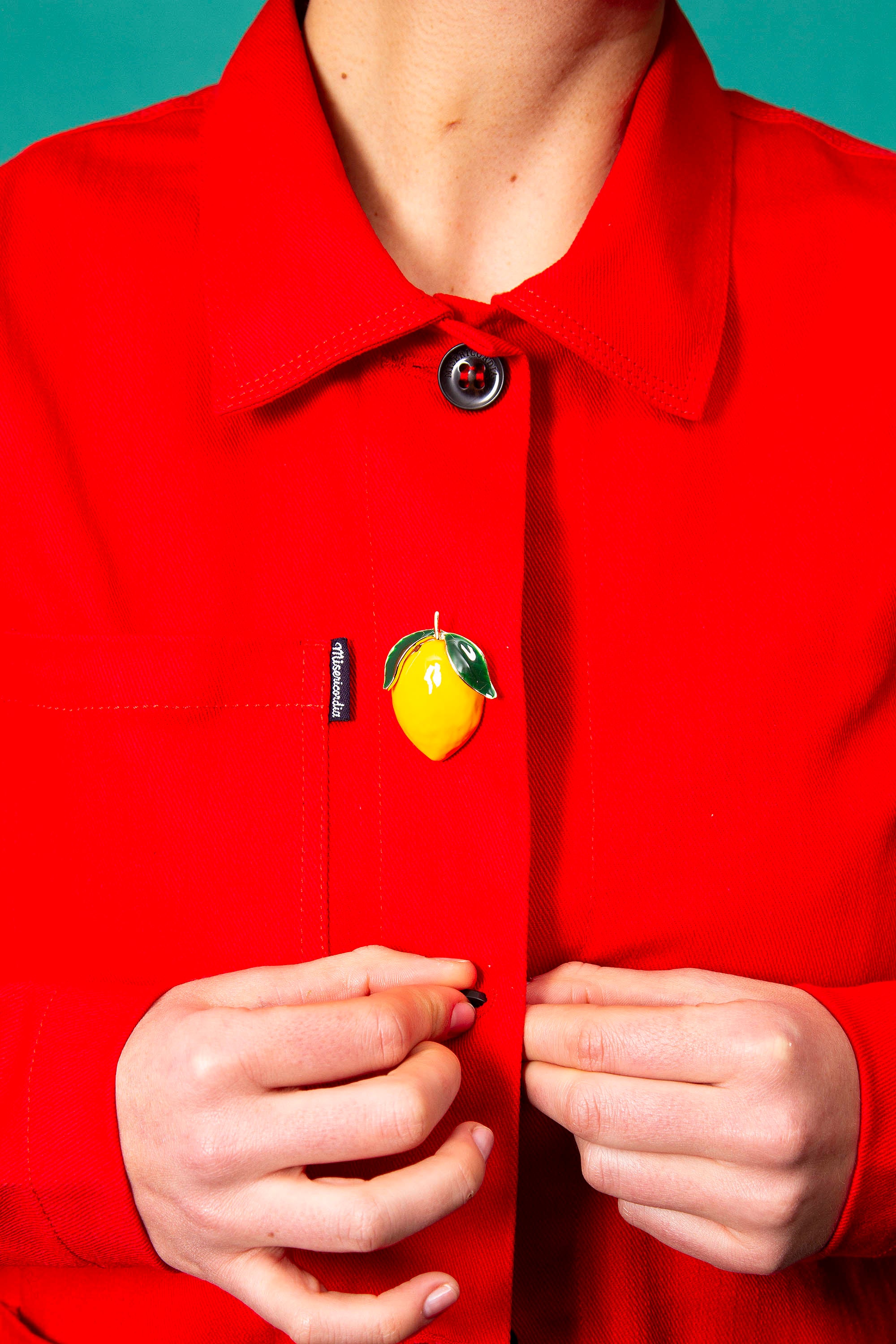 broche citron sur veste rouge cristobal avec femme qui ferme ce blouson veste de travail workwear