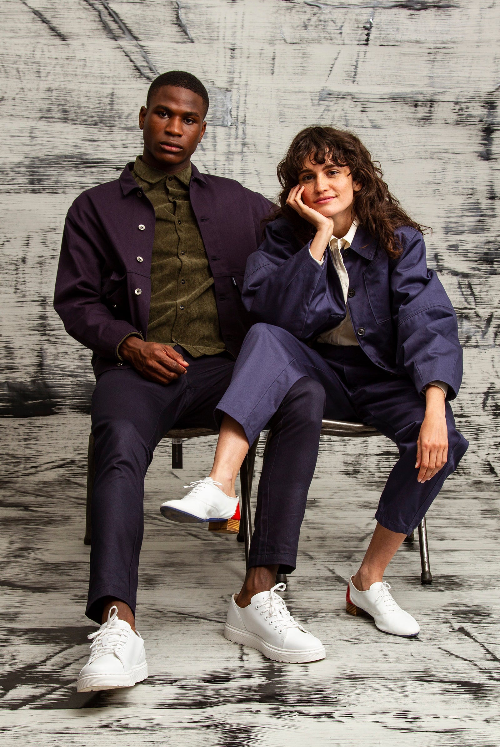 veste en toile bleu marine avec emmanchures descendantes pour l'homme et manteau doublé et ample à manches bouffantes pour la femme