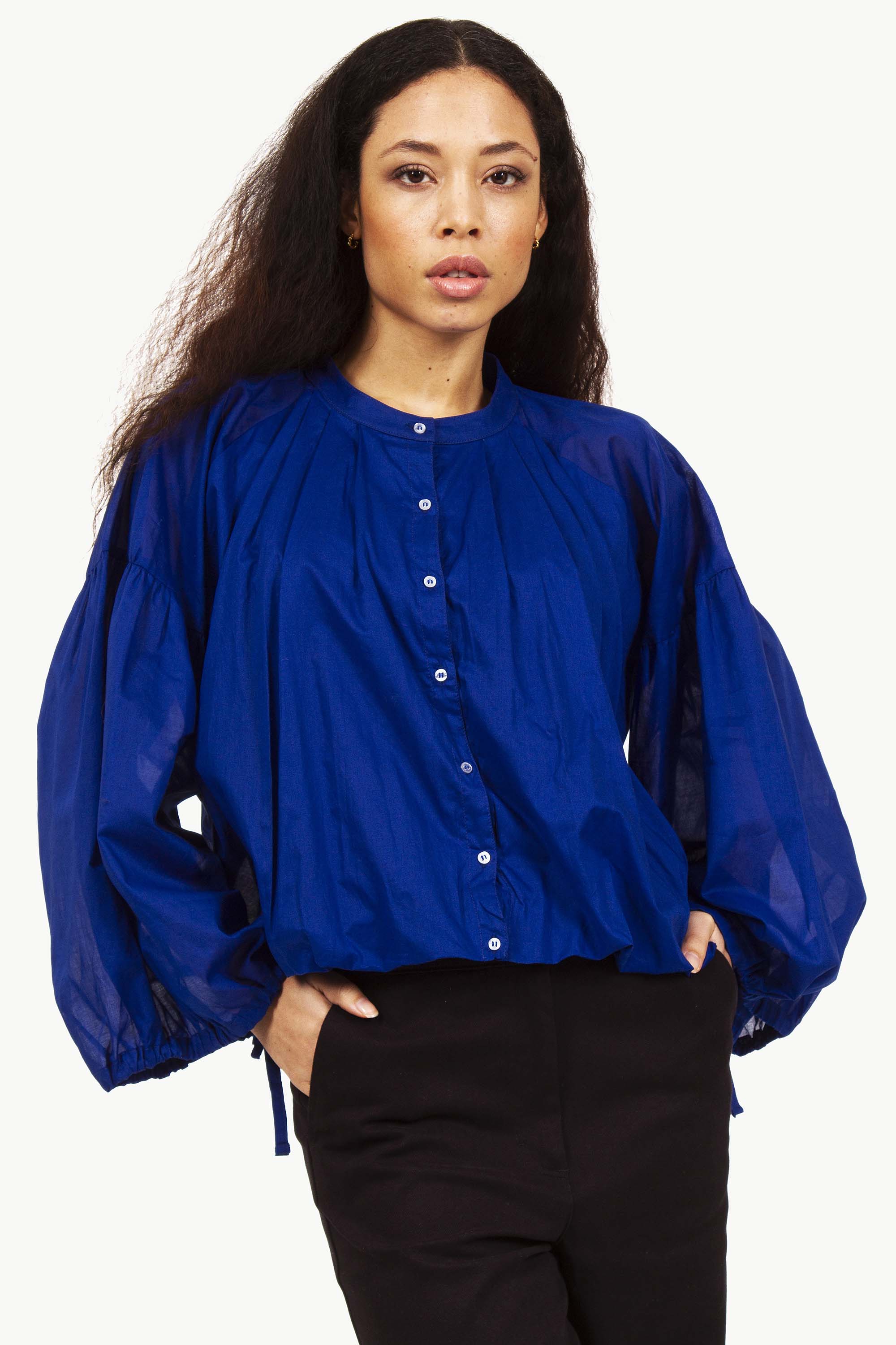 Blouse bleue électrique avec femme les mains dans les poches mode responsable entre paris et lima imagination