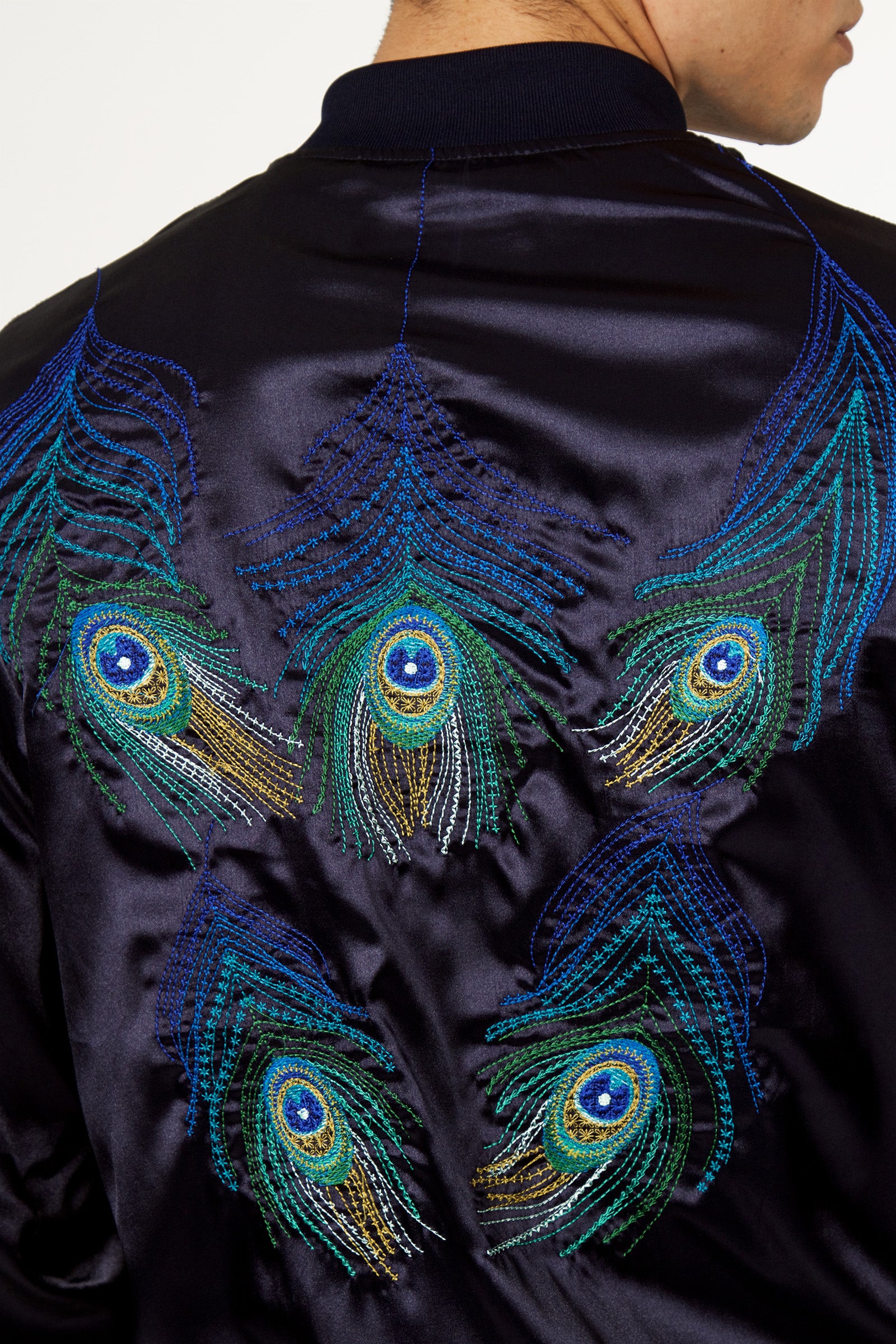 Mannequin homme de dos blouson satin marine avec broderies raffinées plumes de paon 