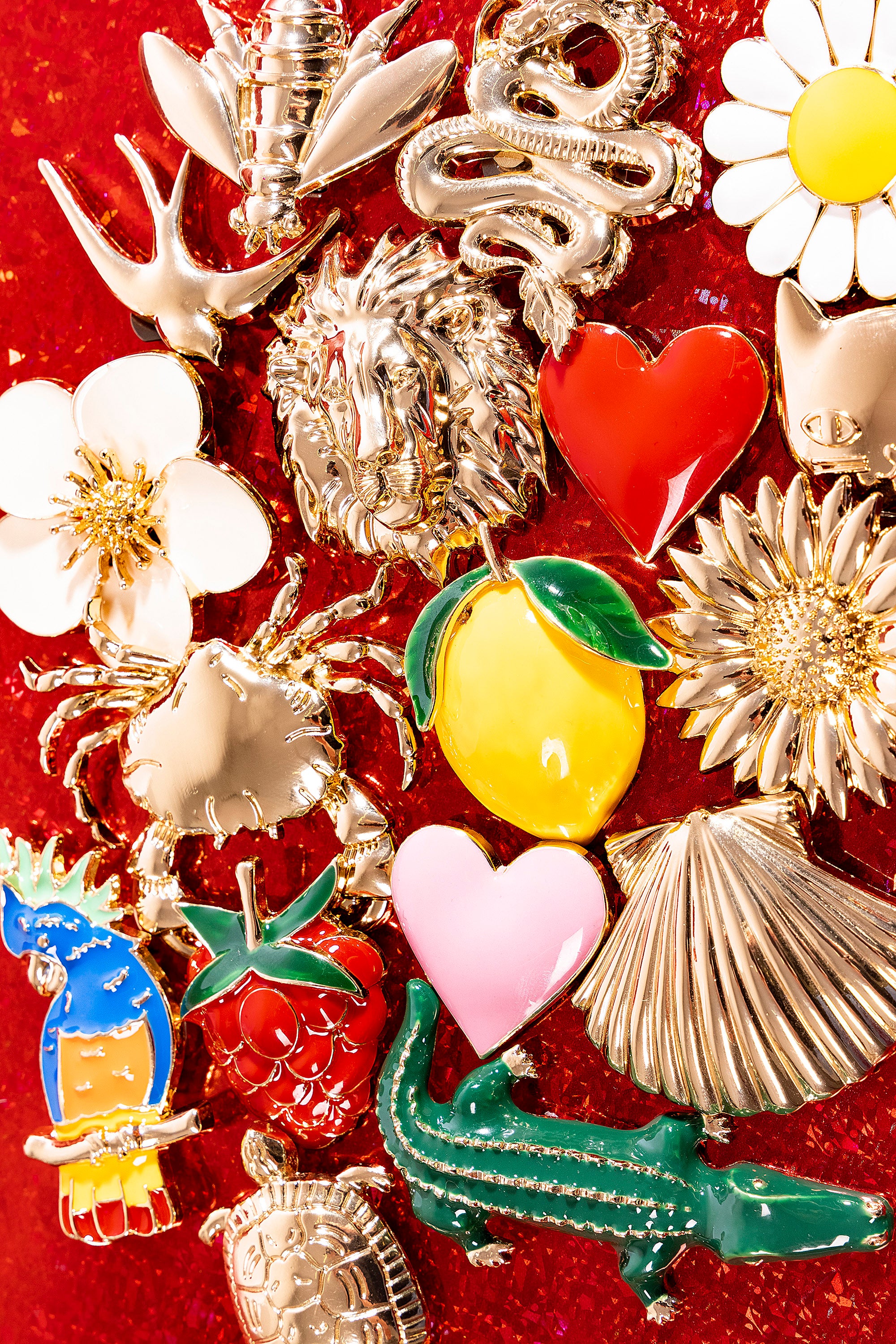 Bijoux clap paris disposés sur fond rouge idées cadeaux broches à clipper misericordia