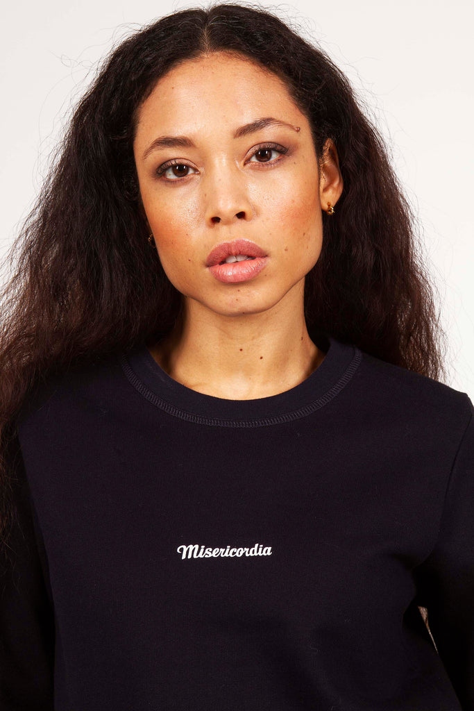 Jolie jeune femme métisse en sweat avec logo Misericordia basique sportswear