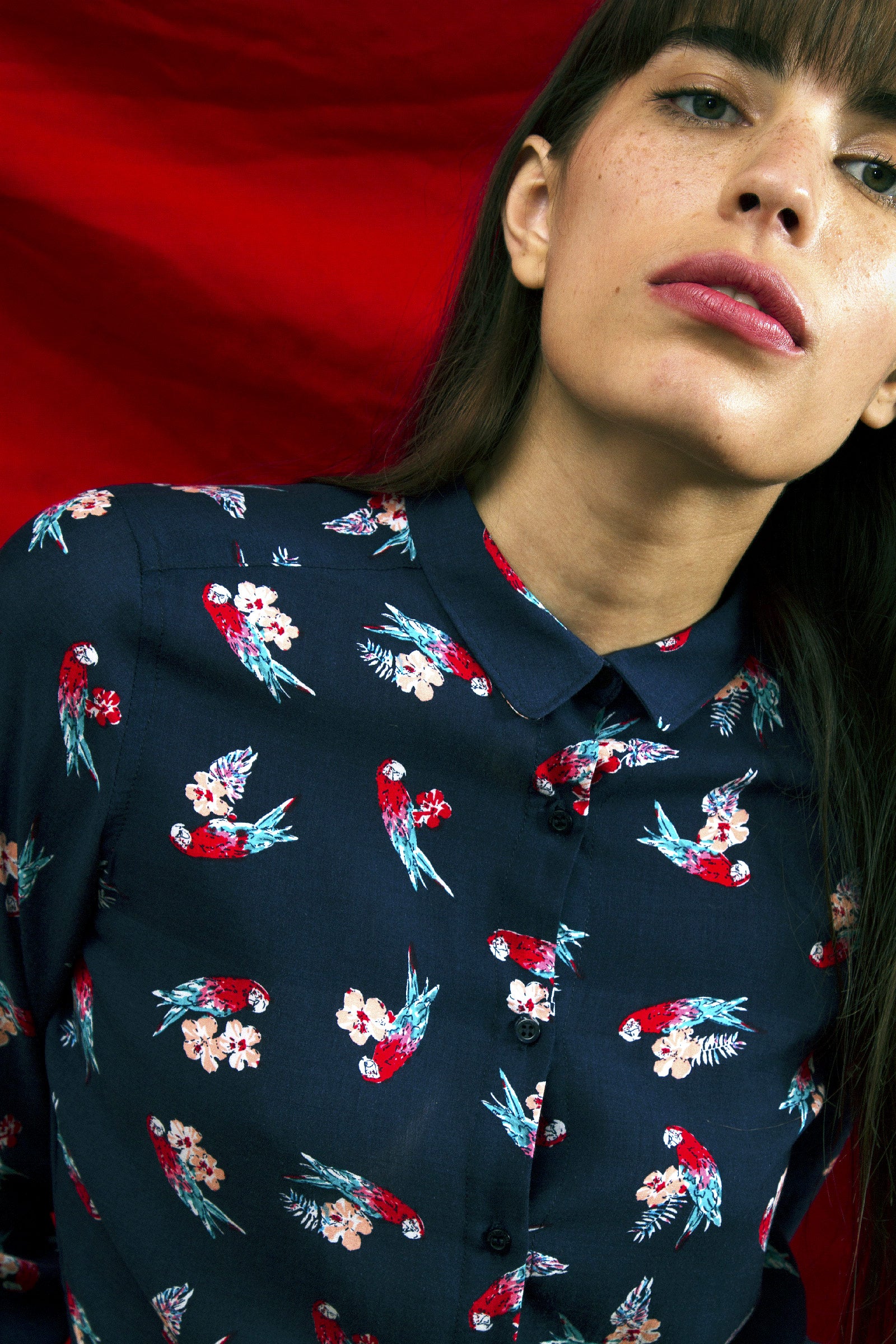 Jeune femme brune aux lèvres pulpeuses porte une chemise à imprimé exotique