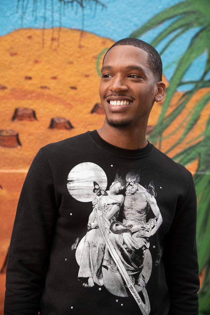 Jeune homme souriant style sport chic en sweat à motif noir et blanc, mode urbaine