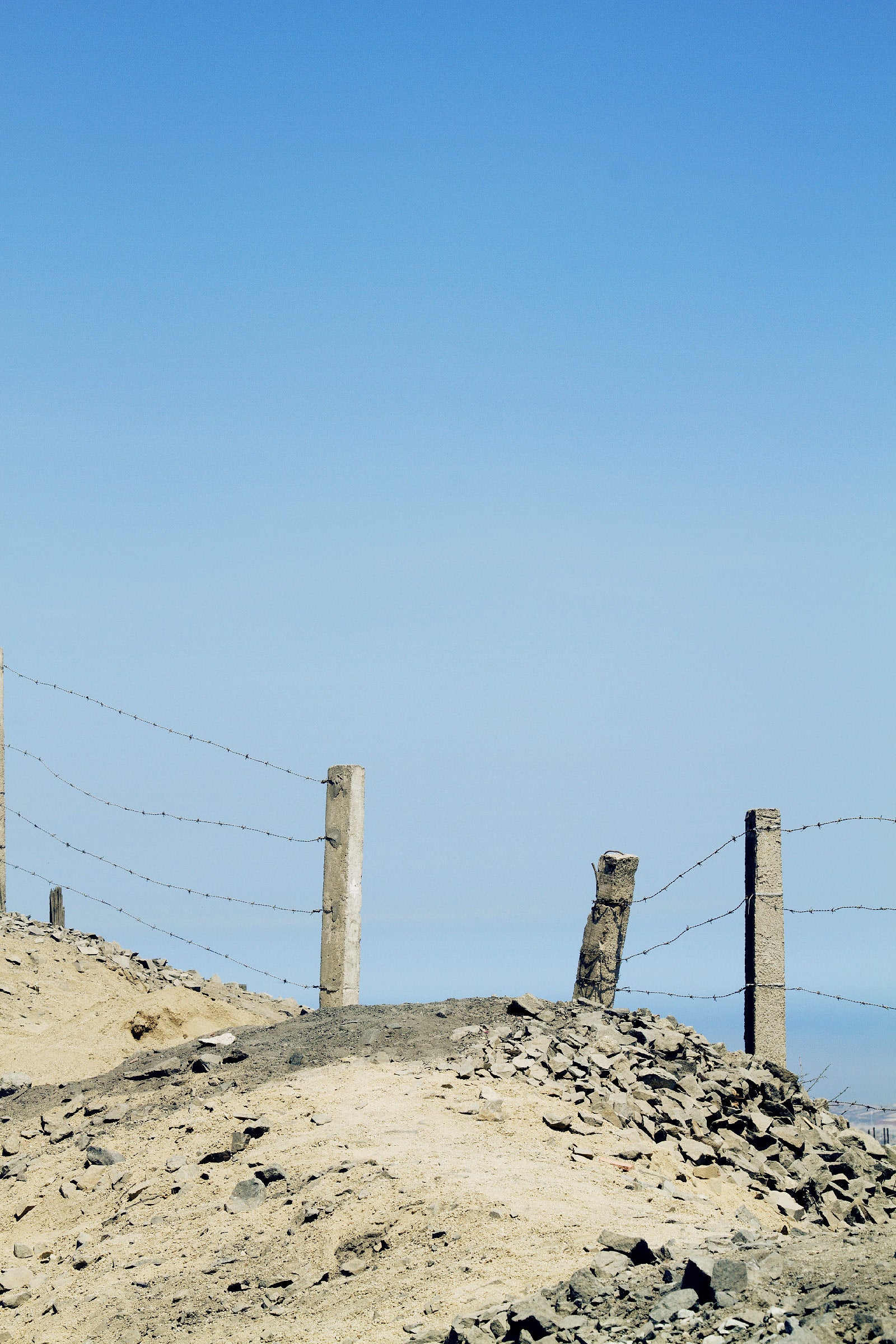 Paysage désertique frontières piliers béton et barbelés