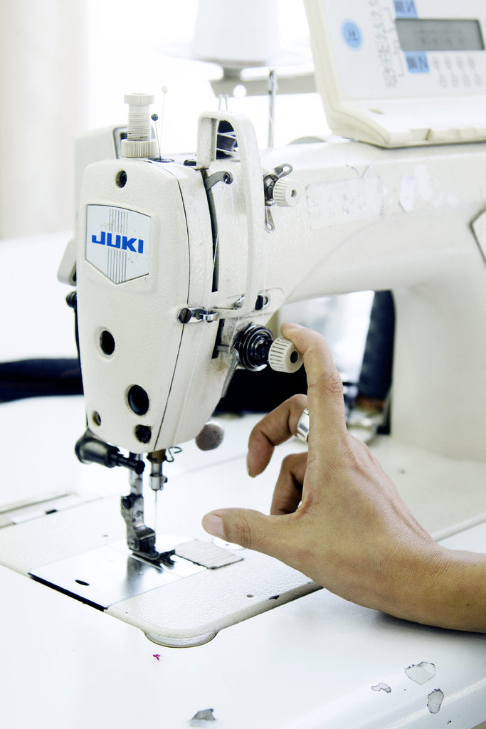 Machine à coudre atelier de couture Lima Pérou détail d'une main tenant le pied de biche