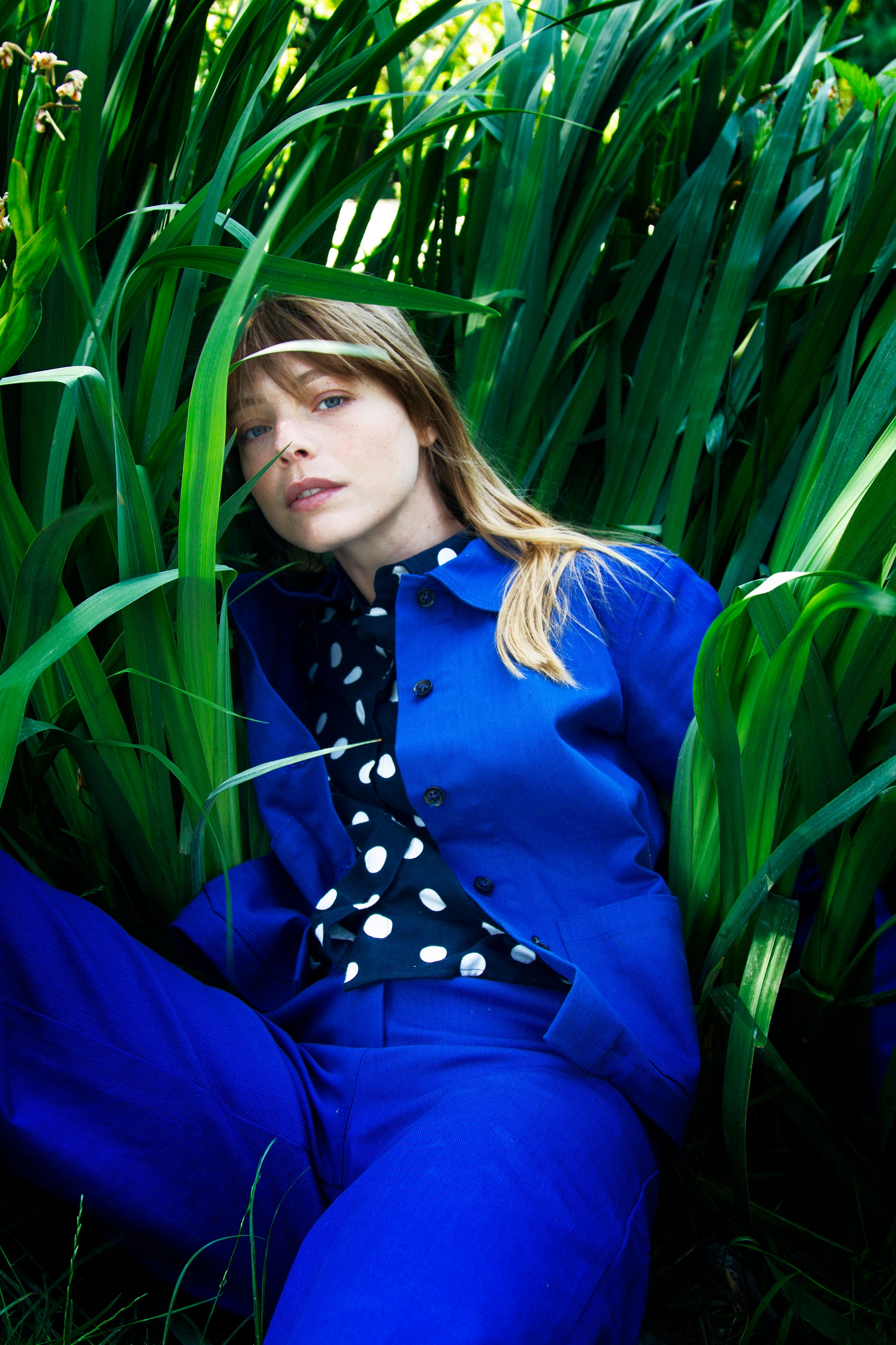 Jeune femme blonde allongée dans l'heure, beauté naturelle fraîcheur et retour aux sources, ensemble bleu de travail en coton
