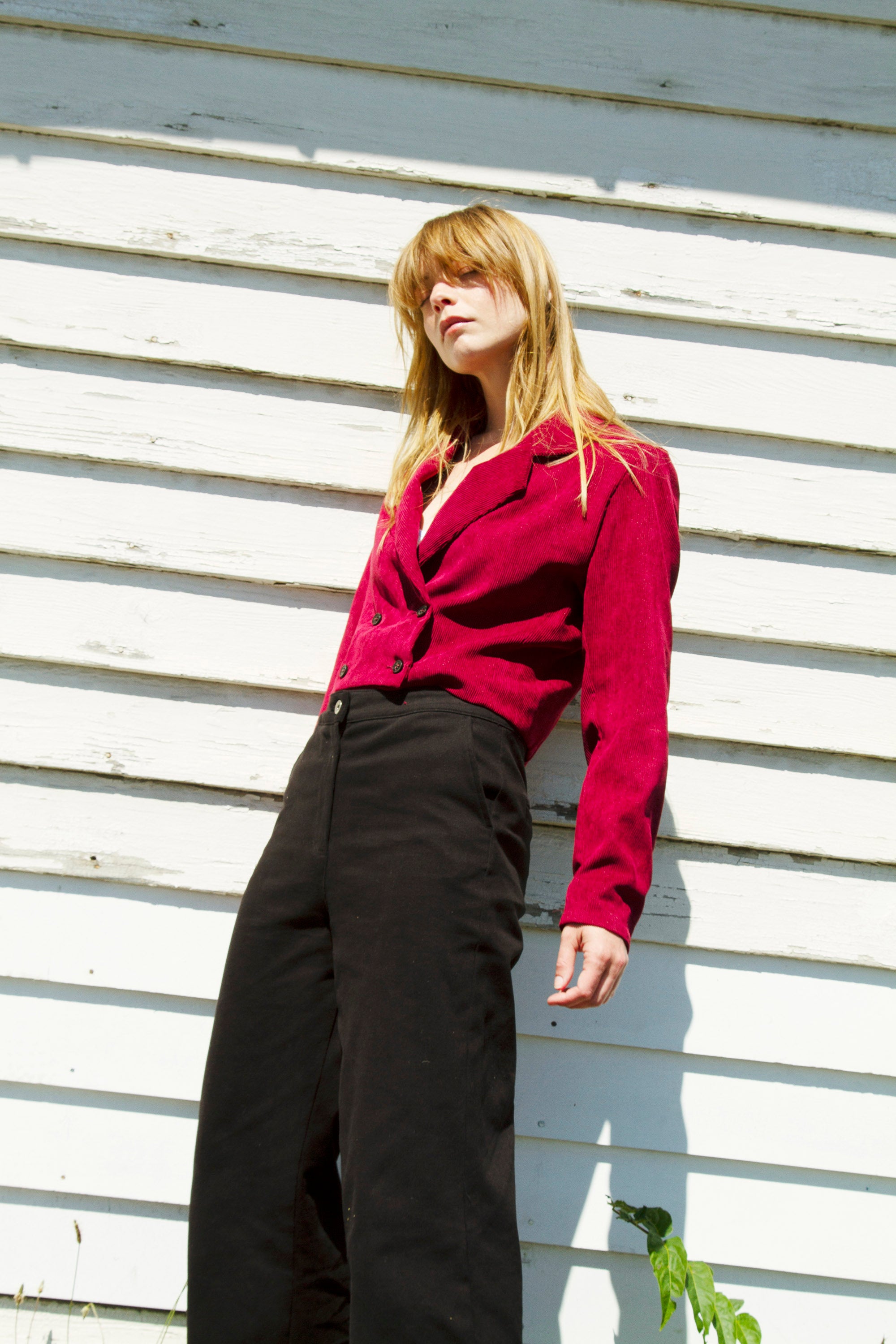 Mannequin femme debout contre un mur nature et féminine veste en velours et pantalon noir développement durable