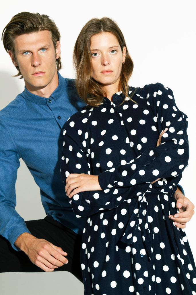 Couple posant devant l'objectif, robe femme en flanelle marine imprimé pois blanc, chemise homme en flanelle blue jeans délavée, collection jeune et citadine